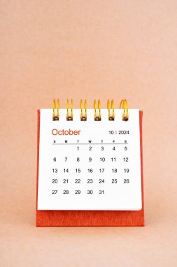 Ekim 2024 kahverengi arkaplan üzerine beyaz masa takvimi.
