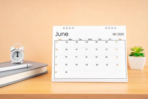 stock image June 2025, Monthly desk calendar for 2025 year on wooden table with diary.