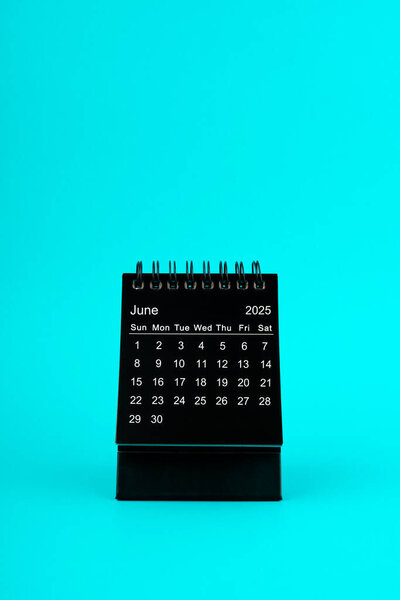 Black Calendar for June 2025. Desktop calendar on a green color background.