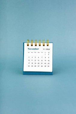 Kasım 2024 mavi arkaplan üzerine beyaz masa takvimi.