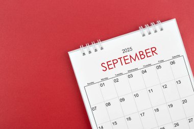 Kırmızı arkaplanda Eylül 2025 masa takvimi.