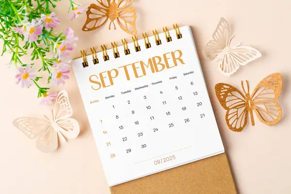 stock image September 2025 desk calendar and paper butterfly with flower on beautiful background.