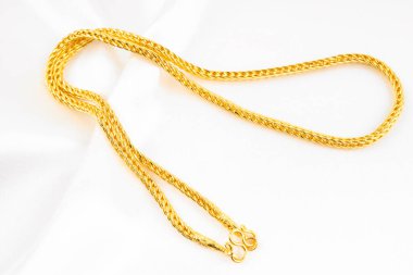 Beyaz renkli ipek arka planda bir Altın Kolye.