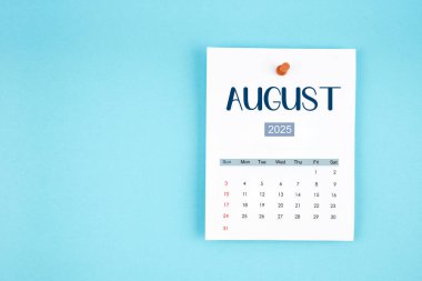 Ağustos 2025 takvim sayfası mavi arkaplandaki iğneye basılı.