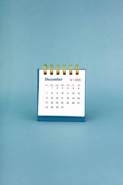 Aralık 2025 mavi arkaplan üzerine beyaz masa takvimi.