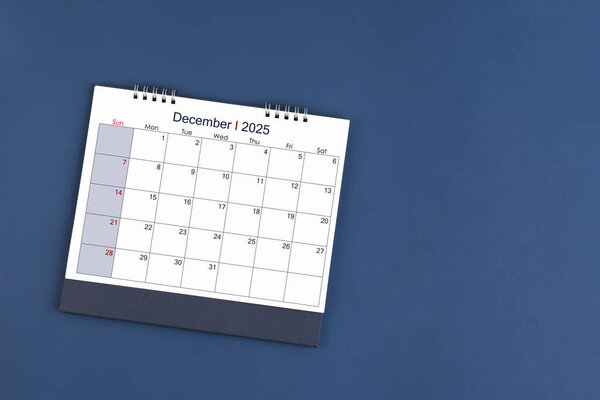 December 2025 Monthly desk calendar for 2025 year on blue color background, Position with copy space. Flat Lay.
