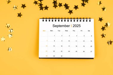 Eylül 2025 takvimi ve sarı arka planda parlayan sarı konfeti yıldızları.