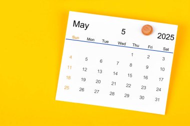 Mayıs 2025 ve ahşap raptiye sarı arka planda