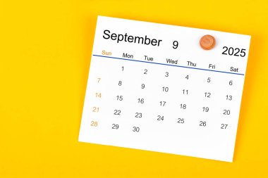 Eylül 2025 ve sarı arkaplanda tahta raptiye.