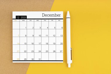 2025 yılı Aralık ayının takvimi. Sarı arka planda bir kalemle..