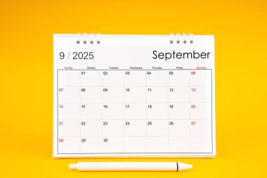 Eylül 2025, 2025 yılı için aylık masa takvimi ve sarı arkaplan üzerine kalem.