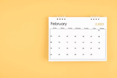 Şubat 2025 sarı arkaplan takvimi, kopyalama alanı olan konum. Zaman planlama günü kavramları.