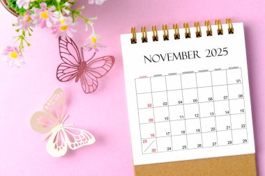 Kasım 2025 Pembe arkaplan üzerinde kelebek planlamak ve hatırlatmak için düzenleyici için masa takvimi.