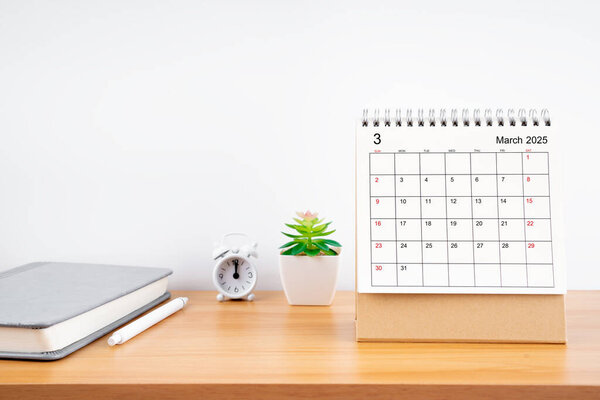 March 2025, Monthly desk calendar for 2025 year on wooden table with diary.