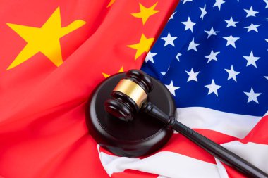 Amerikan ve Çin bayrağının arka planında çekiç hakimi. Adaletin sembolü. Uluslararası hukuk.