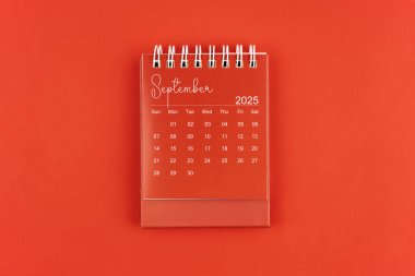 Kırmızı zemin üzerinde kırmızı renkli masa takvimi, Eylül 2025 düz yatıyordu.