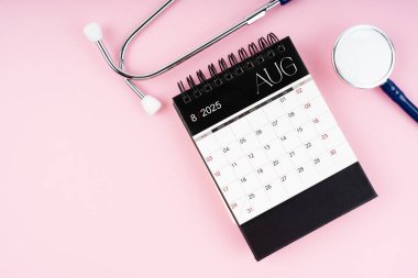 Ağustos 2025 masa takvimi ve steteskop, kontrol edilmesi gereken tıbbi randevu çizelgesi.