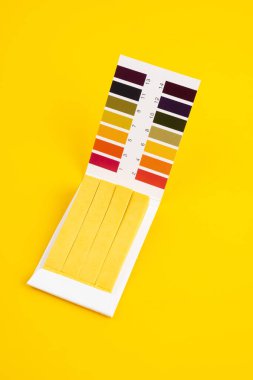 Sarı zemin üzerinde asit testi olan evrensel gösterge kağıdı.