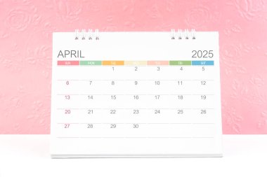 Nisan 2025, arkaplan olarak kabartmalı pembe çiçek desenli masa takvimi.