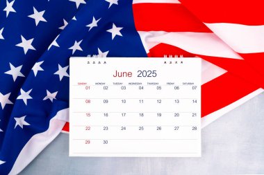 Haziran 2025 masa takvimi ve Amerika Birleşik Devletleri bayrağı ahşap masada, düz yatıyordu..