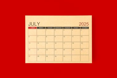 Kırmızı arkaplan üzerine kahverengi kağıt sayfasından yapılan Temmuz 2025 masa takvimi.