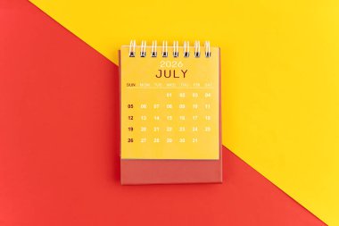 Kırmızı ve sarı arkaplan üzerine Temmuz 2026 masa takvimi.