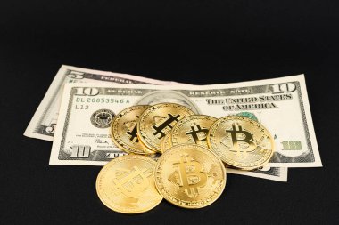 Siyah deri arka planda USD banknotları olan bir yığın bitcoin..