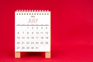 Kırmızı arkaplan üzerine Temmuz 2025 için boş masa takvimi.