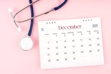 Boş Aralık 2025 masa takvimi ve steteskop, kontrol edilecek tıbbi randevu çizelgesi.