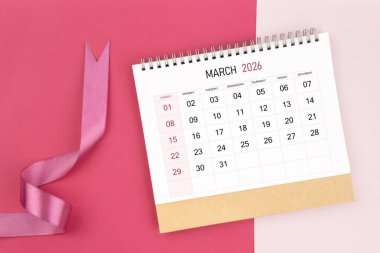 Mart 2026 Masa takvimi ve pembe arkaplan üzerine pembe kurdele.