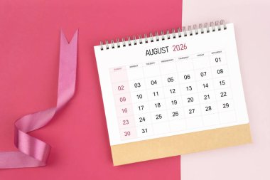 Ağustos 2026 masa takvimi ve pembe renk arkaplan üzerine pembe kurdele.