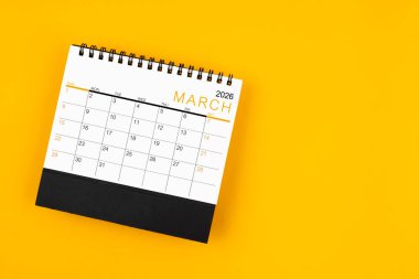 Sarı arkaplan üzerinde Mart 2026 masa takvimi, kopyalama alanı ile konum.