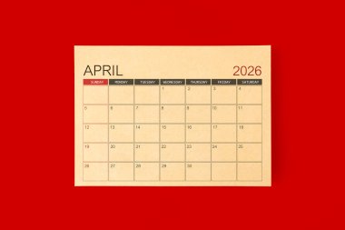 Nisan 2026, kırmızı arkaplan üzerine kahverengi kağıt sayfasından yapılmış masa takvimi.