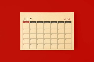 Kırmızı arkaplan üzerine kahverengi kağıt sayfadan yapılan Temmuz 2026 masa takvimi.