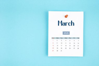 Mart 2026 takvim sayfası mavi arkaplan üzerine pin basın.