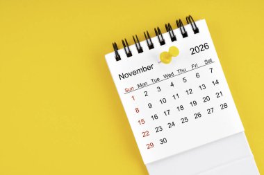 2026 Kasım ayının masa takvimi. Sarı arkaplanda raptiye var..