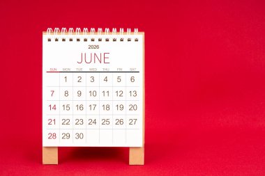 Kırmızı arkaplanda Haziran 2026 için boş masa takvimi.