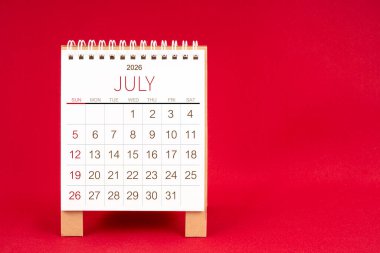 Kırmızı arkaplan üzerine Temmuz 2026 için boş masa takvimi.