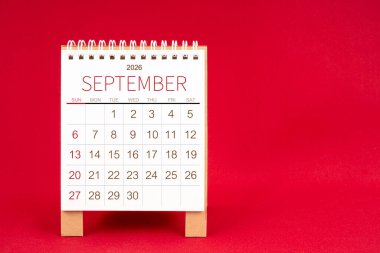 Kırmızı arkaplan üzerine Eylül 2026 için boş masa takvimi.