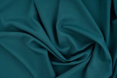Güzel koyu mavi ipek saten arka plan. Yumuşak kıvrımlar parlak kumaş üzerinde. Tasarım için kopyalama alanı olan lüks arkaplan.