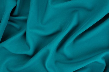 Güzel koyu mavi ipek saten arka plan. Yumuşak kıvrımlar parlak kumaş üzerinde. Tasarım için kopyalama alanı olan lüks arkaplan.