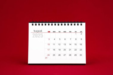 Ağustos 2025 Kırmızı arkaplanda boş masa takvimi.