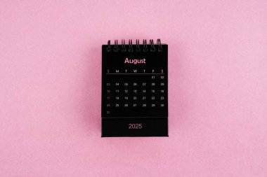 Pembe arka planda Ağustos 2025 için siyah takvim.
