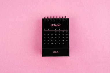 Pembe arka planda Ekim 2025 için siyah takvim.