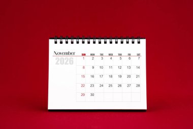 Kasım 2026 Kırmızı arkaplanda boş masa takvimi.