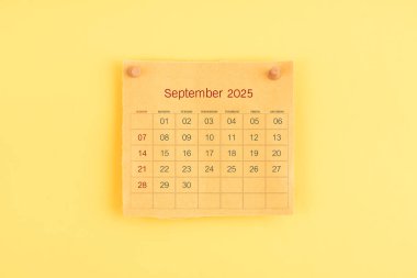 Eylül 2025 kahverengi takvim üzerinde ahşap raptiye.