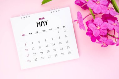 Mayıs 2026 Masa takvimi ve pembe arkaplanda pembe orkide.