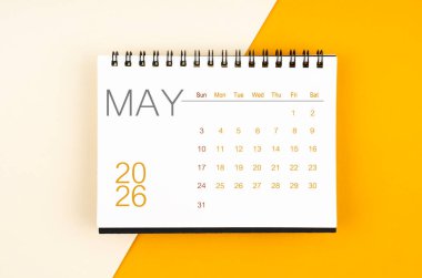 Sarı zemin üzerinde Mayıs 2026 için masa takvimi, düz yatıyordu.