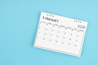 Mavi arka planda 2026 yılı için Şubat 2026 Aylık masa takvimi.