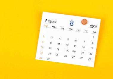 Ağustos 2026 Kart takvimi ve sarı duvarda tahta raptiye.